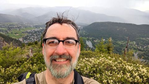 Victor overlooking a valley from a high ridge.